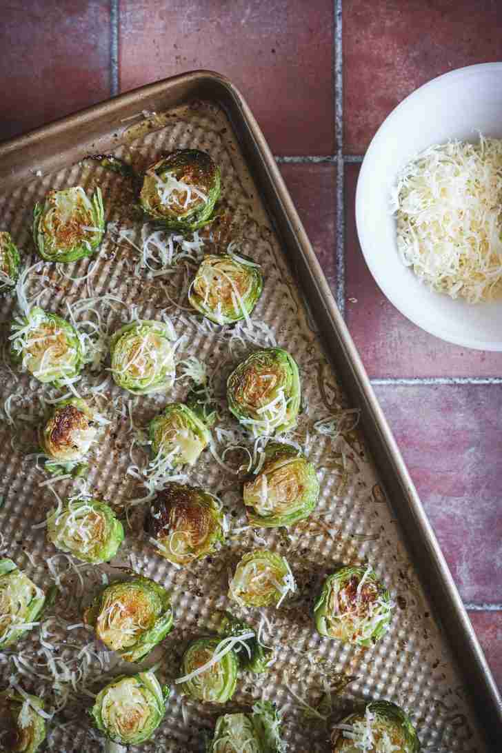 Brussels sprouts halved and arranged on a baking sheet, glistening with oil, salt, and pepper, ready to be roasted until tender and caramelized.