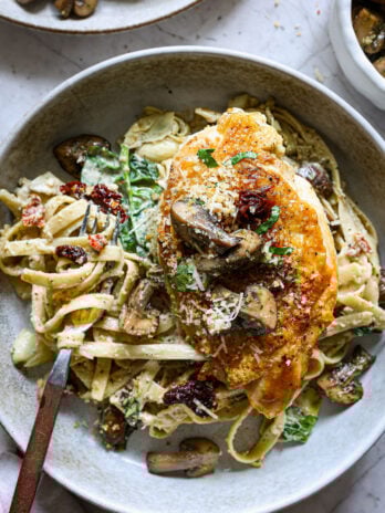 Pan-seared chicken breast over creamy fettuccine with spinach, mushrooms, sun-dried tomatoes, and Parmesan breadcrumbs.